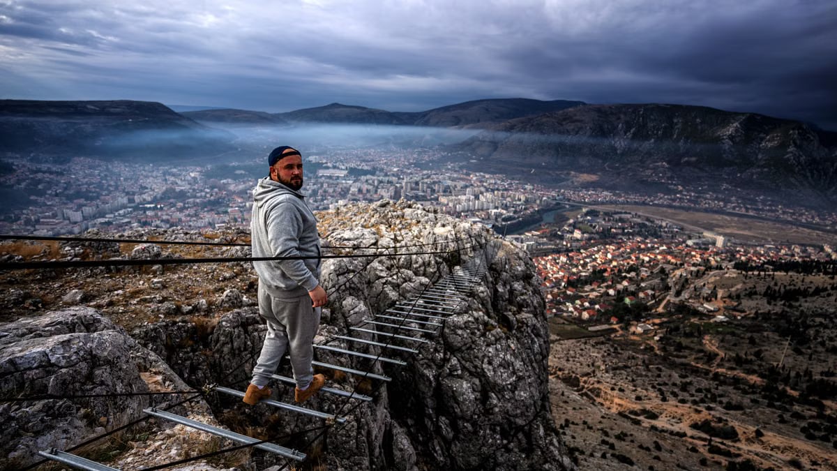A man looks back while walking on a narrow mountain trail above Mostar, Bosnia.